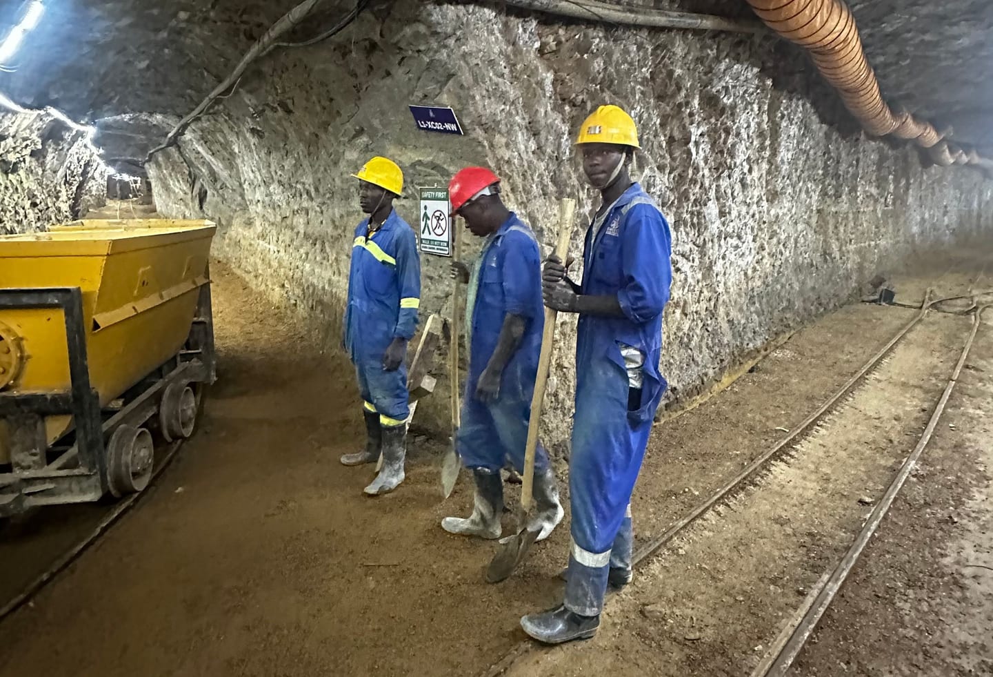 Miners with an ore cart in an underground haulage tunnel.